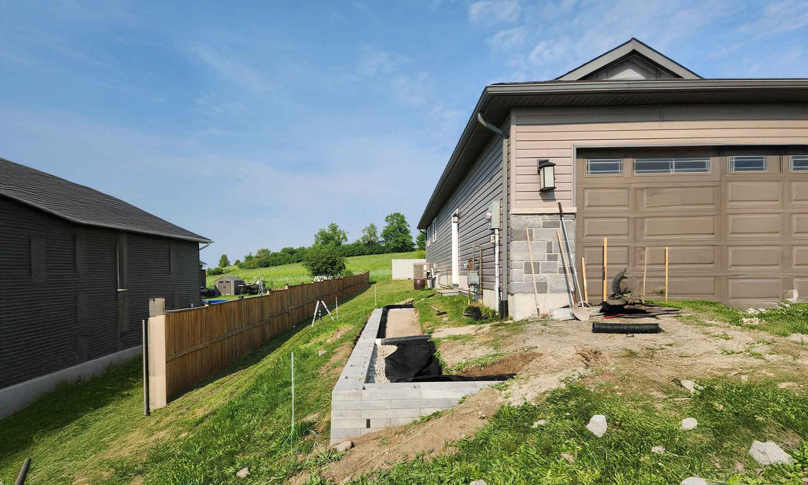 Residential exterior upgrade showing early foundation work and site grading prior to deck construction